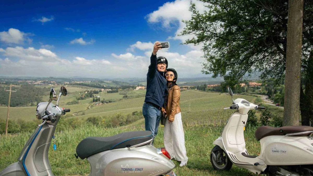 Riders on Vespas between Chianti vineyards on a Vespa tour