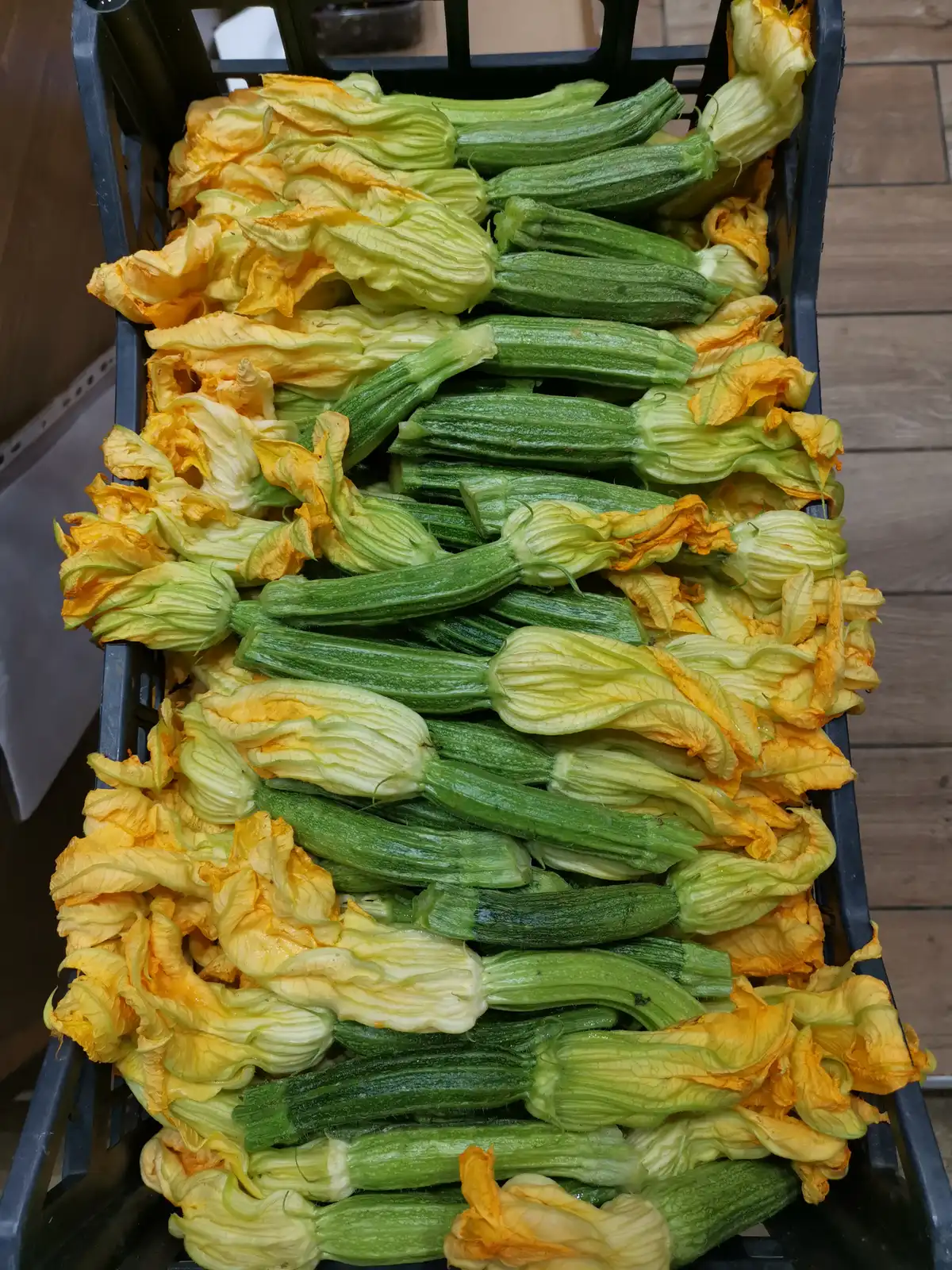 A crate of zucchini flowers at a produce stall in the Mercato Centrale